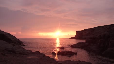 Sunset,-Sea-washing-rocks,-Pink-Clouds