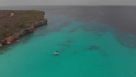 Epische-Luftaufnahme-Eines-Ausflugsbootes,-Das-Im-Kristallklaren-Wasser-Von-Grote-Knip-Auf-Der-Niederländischen-Karibikinsel-Curaçao-Schwimmt