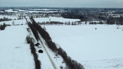 Amazing-aerial-view-from-alley-road-to-the-wintery-forest-horizon