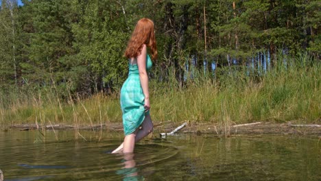 Redhead-woman-walking-in-water-in-lake