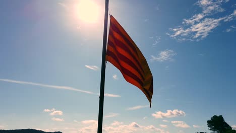 Katalanische-Flagge-In-Der-Sonne-Mit-Blauem-Himmel-Und-Einigen-Wolken