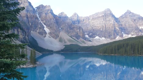 Vista-Panorámica-Del-Lago-Moriane--uno-De-Los-Lagos-Más-Famosos-De-Canadá--Temprano-En-La-Mañana-Con-El-Reflejo-De-La-Cordillera-Rocosa-En-La-Superficie-Del-Lago-En-El-Parque-Nacional-De-Banff,-Alberta,-Canadá