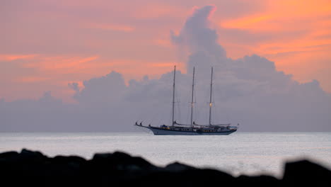 Yacht-at-anchor-against-a-backdrop-of-golden-clouds-at-dusk