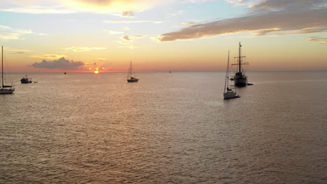 Aerial---Yachts-at-anchorage-on-peaceful-afternoon-with-sun-on-horizon