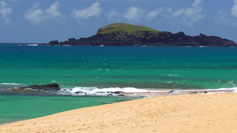 Scenic-view-of-small-island-off-the-coast-of-a-tropical-Hawaian-beach