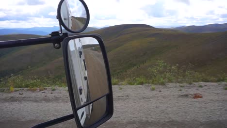 Static-view-looking-at-a-mirror,-while-driving-on-the-Top-of-the-World-Highway,-inside-a-camper-van,-up-in-the-Yukon-highlands,-on-a-cloudy-day,-in-Canada