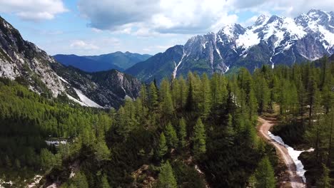 Forward-drone-shot-of-Vrsic-Pass,-Slovenia,-on-a-sunny-day-with-some-clouds