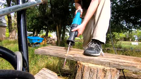Male-cutting-lumber-in-the-backyard-for-fire-wood