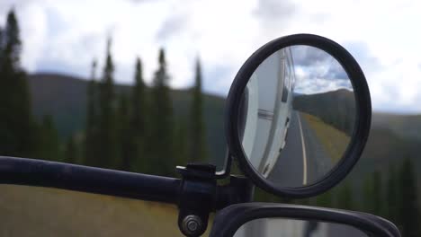Static-view-looking-at-a-mirror,-while-driving-on-the-Top-of-the-world-highway,-inside-a-work-truck,-in-Alaskan-wilderness,-on-a-cloudy-day,-in-Alaska,-USA