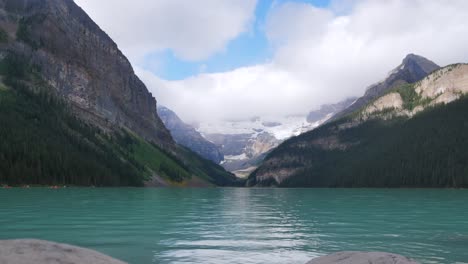 Zeitraffer-Landschaftsansicht-Des-Lake-Louise---Einer-Der-Berühmtesten-Seen-Im-Banff-Nationalpark,-Alberta,-Kanada---Im-Sommer-Tagsüber-Nach-Regen-Mit-Wolken-Am-Himmel-Und-Menschen,-Die-Im-See-Kanu-Fahren