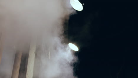 Steam-rising-in-slow-motion-at-night-towards-potlights