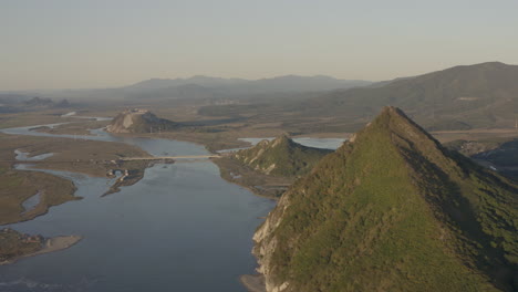 Landschaftsansicht-Einer-Flussmündung-Mit-Zwei-Pyramidenförmigen-Bergen-Und-Einem-Bergrücken-Im-Hintergrund-Bei-Sonnenuntergang