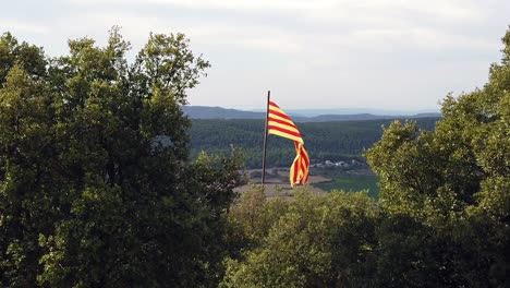 Zeitlupe-Der-Katalanischen-Flagge-Auf-Einem-Hügel-Mit-Blick-Auf-Hügel-Mit-Bewölktem-Himmel