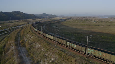 Locomotora-Estacionaria-De-Vagón-De-Carga-De-Carbón-Completamente-Cargada,-Detenida-En-El-Giro-Curvo-Del-Ferrocarril,-Al-Atardecer
