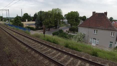 A-view-of-the-buildings,-Wolin-station-and-the-trees-from-a-moving-train