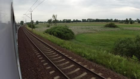 A-view-of-the-train-tracks-and-the-fields-from-a-fast-moving-train