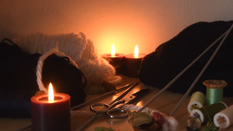 Cozy-background-of-a-knitting-table-with-candles-and-knitting-equipment
