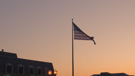 An-American-flag-waves-in-the-breeze-at-sunset-in-slow-motion
