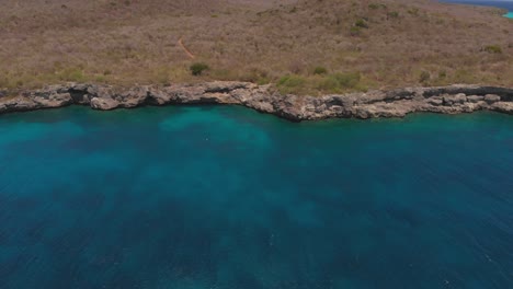 Amazing-aerial-of-an-almost-submerged-cave-found-in-the-cliffs-of-West-Coast,-Curacao