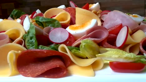 Colorful-family-food-platter-made-of-vegetables,-soft-boiled-eggs,-salami,-and-cheese,-SLIDE-RIGHT