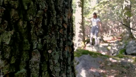 Revealing-shot-of-young-girl-hiking-in-a-deep-forest,-PAN-RIGHT,-SLOMO