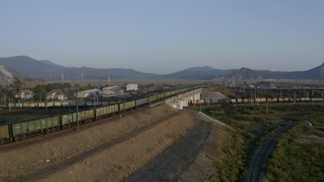 Trenes-De-Carga-De-Carbón-Vacíos-Y-Llenos-Que-Se-Mueven-En-La-Intersección-De-Los-Ferrocarriles-Con-El-Puente-Ferroviario,-Al-Atardecer