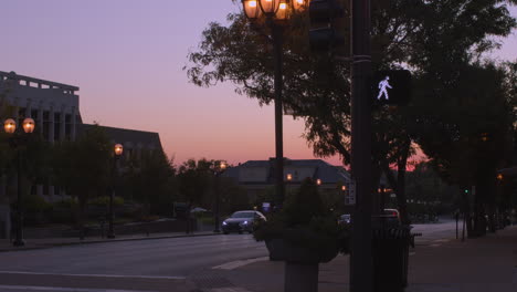 First-person-view-of-crossing-a-street-at-sunset-with-a-walk-sign-lit