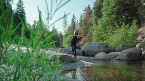 Low-Angle,-Blonde-Woman-Casting,-Fly-fishing-in-rocky-mountain-river
