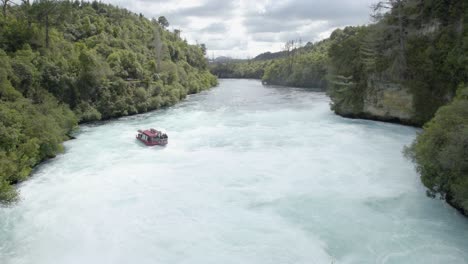 A-wide-shot-from-the-end-of-the-Huka-Falls-as-a-cruise-boat-approaches