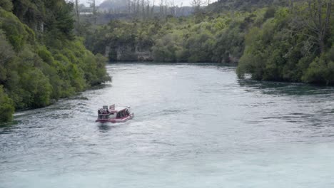 Eine-Aufnahme-Des-Huka-Falls-Kreuzfahrtboots,-Das-Langsam-Den-Waikato-Fluss-Heraufkommt,-Bevor-Es-Das-Bild-Verlässt