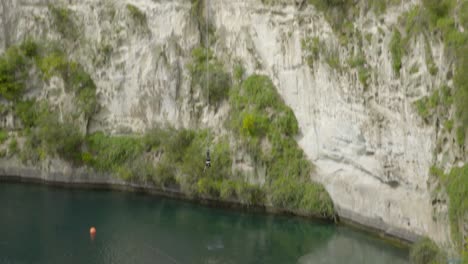 A-tracking-shot-of-someone-bungy-jumping-from-a-platform-over-the-Waikato-river-in-Taupo,-NZ