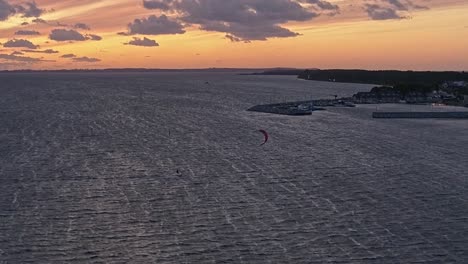 Silhouette-Of-A-Man-On-A-Kite-Board-In-The-Sea-At-Sunset,-Aerial-View