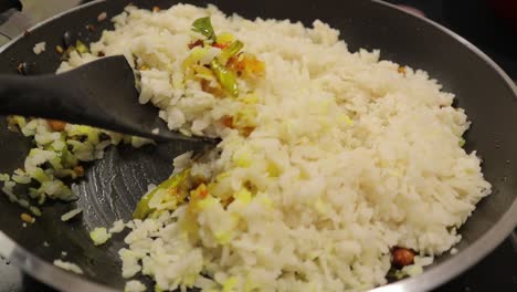 Zubereiten-Von-Frischem-Südindischem-Frühstück-Oder-Snacks-Poha,-Mischen-Von-Rohem-Poha-Oder-Abgeflachtem-Reis-Mit-Gemüse-Und-Zutaten-In-Der-Pfanne