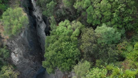 4K-AERIAL-TRUCK-LEFT:-Drone-flying-above-Alcantara-Gorges,-an-impressive-channel-of-lava-columns-eroded-naturally-into-ravines,-canyons-and-caves,-tilt-down