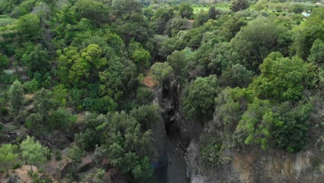 4K-AERIAL-DOLLY-IN:-Drone-flying-above-Alcantara-Gorges,-an-impressive-channel-of-lava-columns-eroded-naturally-into-ravines,-canyons-and-caves