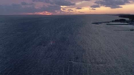 Silhouette-Eines-Mannes-Auf-Einem-Kiteboard-Im-Meer-Bei-Sonnenuntergang,-Luftbild