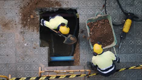 Top-View-Of-Constructor-Workers-Digging-Shoveling-and-Breaking-a-Concrete-on-a-street-in-Barcelona-in-slow-motion