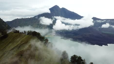 AERIAL-4K-Panning-Up-Shot-of-Foggy-Mount-Rinjani-with-Crater-Lake-in-View,-Indonesia