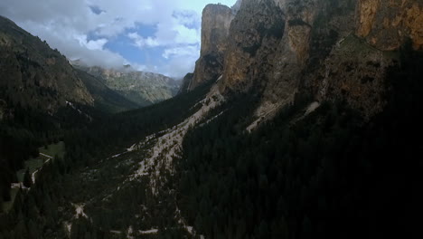 Dark-and-imposing-view-of-a-wild-and-rugged-valley-with-high-cliffs,-dark-forests-and-dramatic-clouds-in-the-sky