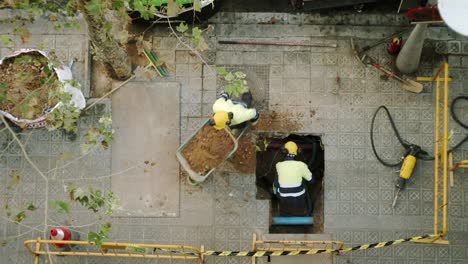 Top-View-Of-Constructor-Workers-Digging-Shoveling-and-Breaking-a-Concrete-on-a-street-in-Barcelona