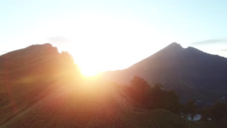 AERIAL-4K-Side-Panning-Shot-Standing-on-Crater-Rim,-Sunrise-Mount-Rinjani-Volcano,-Indonesia