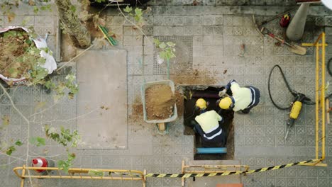 Top-View-Of-Constructor-Workers-Digging-Shoveling-and-Breaking-a-Concrete-on-a-street-in-Barcelona