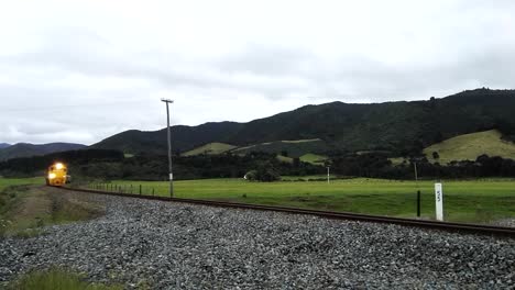 A-commuter-train-driving-towards-and-past-camera-in-Featherston,-New-Zealand