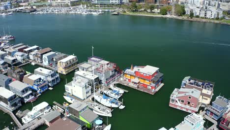 A-colorful-and-vibrant-pass-over-house-boats-in-the-marina-as-the-camera-reveals-the-large-city-in-proximity