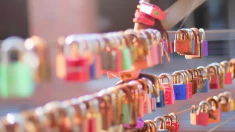 Close-up-of-a-group-of-padlocks,-hanging-on-a-steel-cable