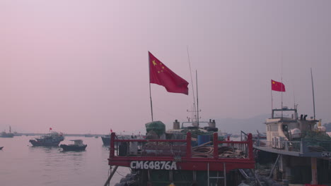 Chinesische-Flagge-Im-Wind-Auf-Einem-Kleinen-Boot-Bei-Sonnenuntergang-In-Einem-Kleinen-Hafen