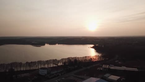 Lake-in-Olsztyn-town-at-sunset,-aerial-view,-Poland