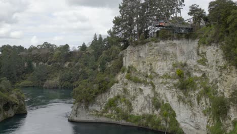 A-static-wide-shot-of-someone-doing-the-giant-swing-over-the-Waikato-river-in-Taupo,-NZ