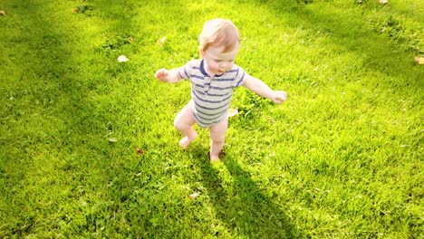 Glückliches-Kleinkind-Macht-Erste-Schritte-Allein-Im-Gras