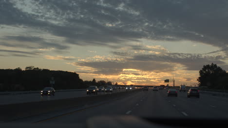 POV-of-driver-driving-on-a-highway-at-sunset